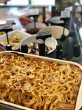 Pasta fresca al forno artigianale in teglia, esposta in un banco gastronomia emiliana