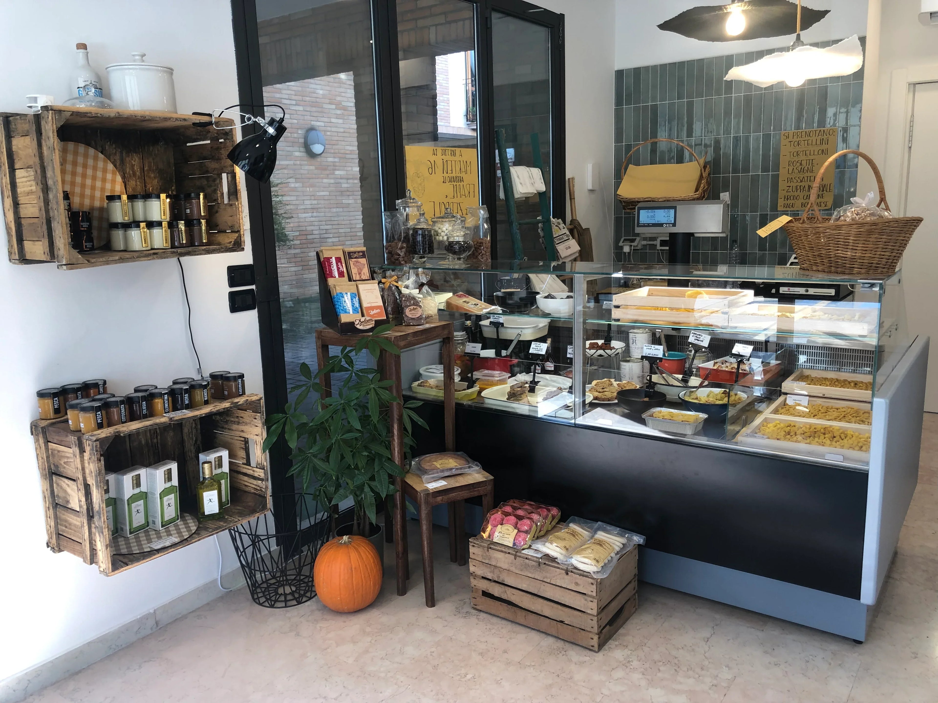Negozio artigianale di pasta fresca con vetrina di tortellini, tortelloni e prodotti emiliani.