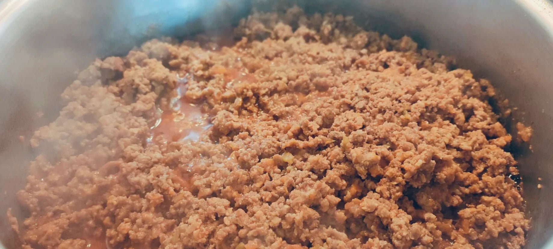 Ragù emiliano tradizionale con carne macinata in cottura in pentola